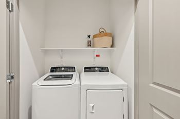 A small laundry room with a washer and dryer. at The Concord Luxury Apartments, Sarasota, FL, 34240